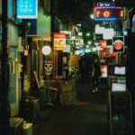 Neon-lit narrow alley in Shinjuku Golden Gai at night with glowing bar signs