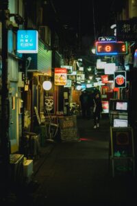 Neon-lit narrow alley in Shinjuku Golden Gai at night with glowing bar signs