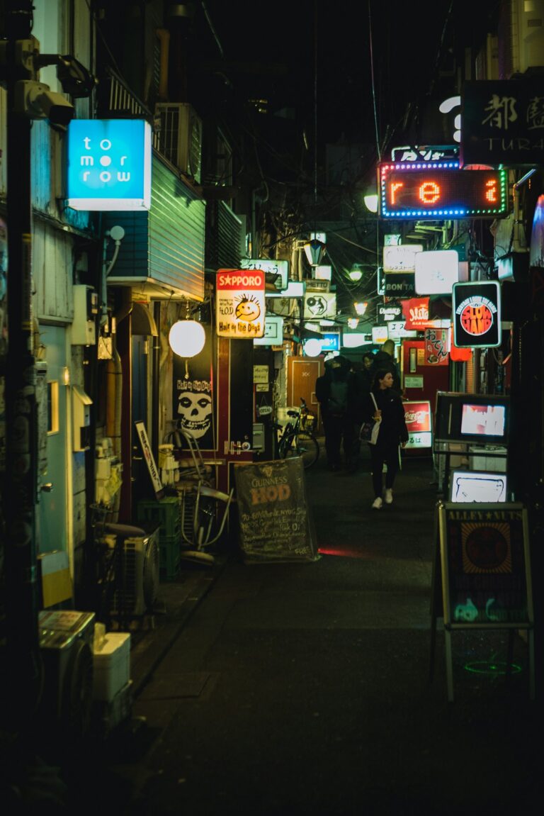 Neon-lit narrow alley in Shinjuku Golden Gai at night with glowing bar signs