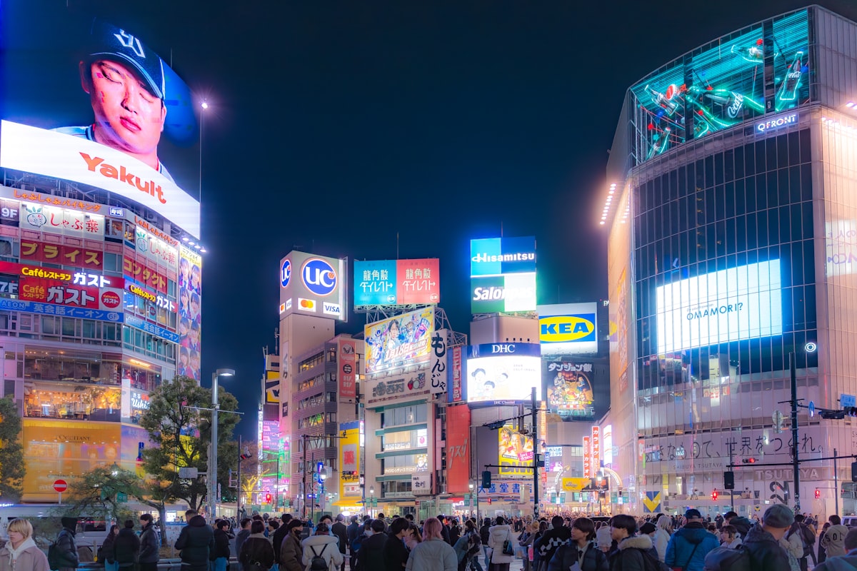 Shibuya Crossing at night with neon lights and crowds