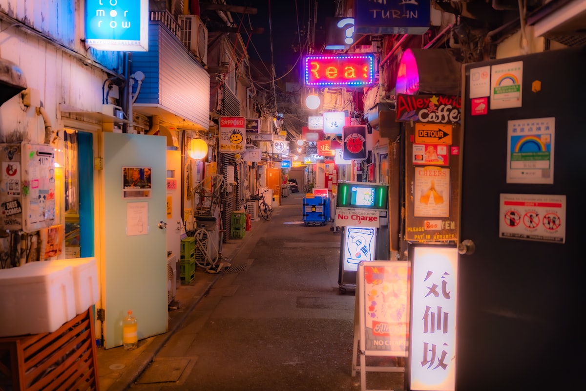 Narrow neon-lit alleyway shimmering at night in Shinjuku Tokyo