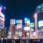 Shibuya crossing at night with neon signs, starting point for solo travelers in Tokyo