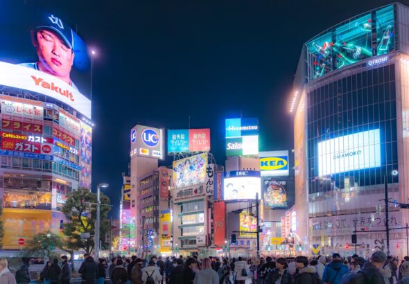 Shibuya crossing at night with neon signs, starting point for solo travelers in Tokyo