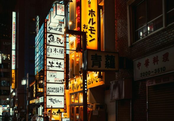 Neon signs illuminate a Shinjuku street in Tokyo at night
