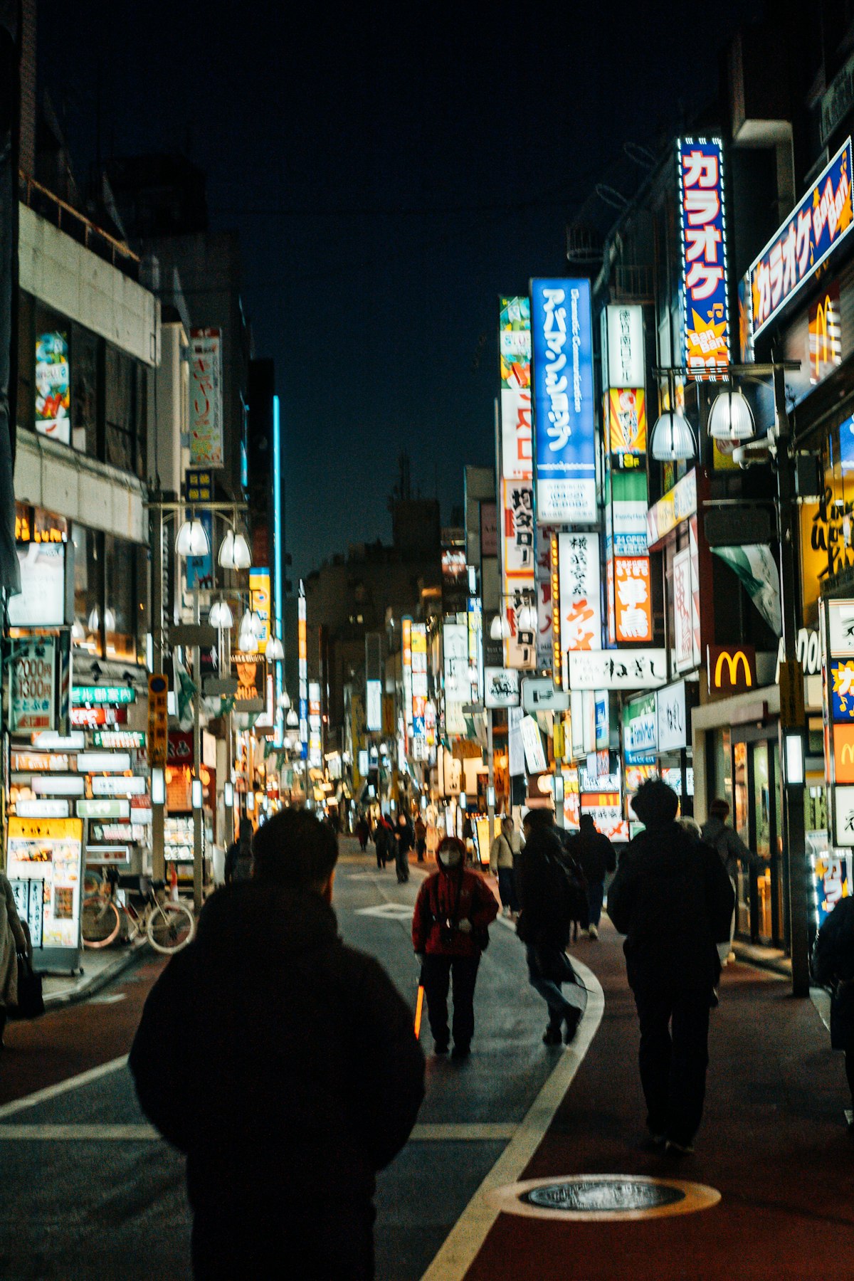 People walking through a busy Kabukicho street at night