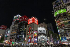Stacked neon signs on a Kabukicho building in Shinjuku, Tokyo, where girls bars and hostess clubs often occupy floors of the same building