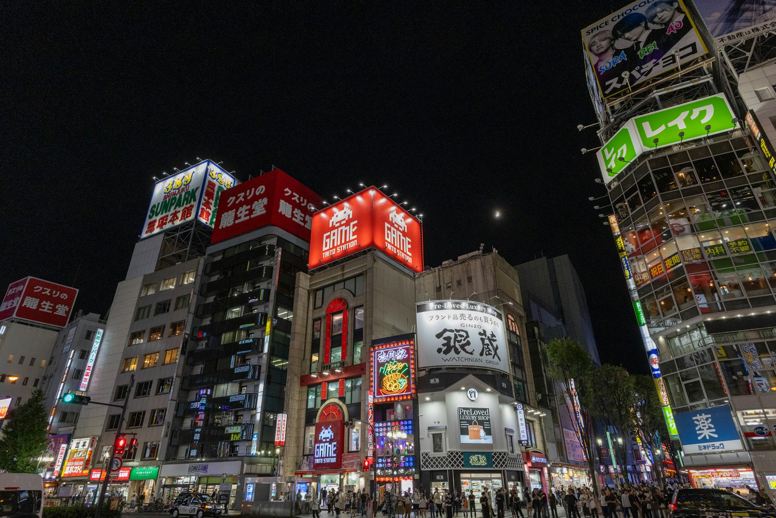 Stacked neon signs on a Kabukicho building in Shinjuku, Tokyo, where girls bars and hostess clubs often occupy floors of the same building