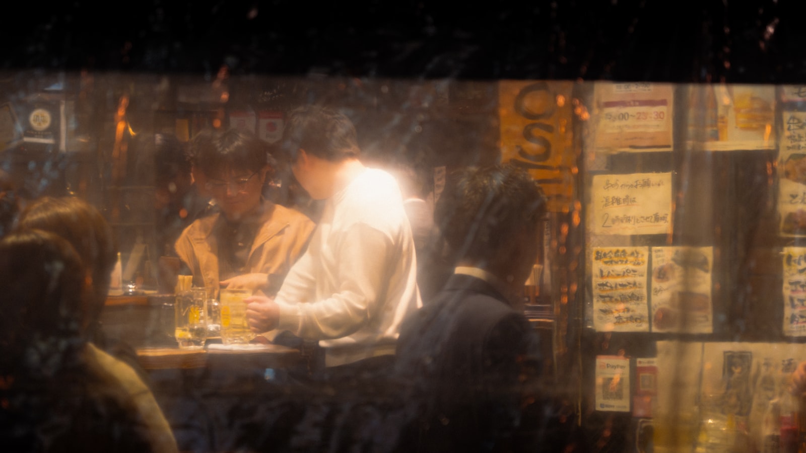 A softly lit Japanese bar counter with glasses and bottles, illustrating the counter service format that defines a girls bar