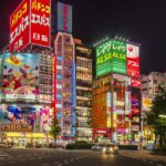 Neon signs of hostess clubs and bars lining a Kabukicho street in Shinjuku, Tokyo at night
