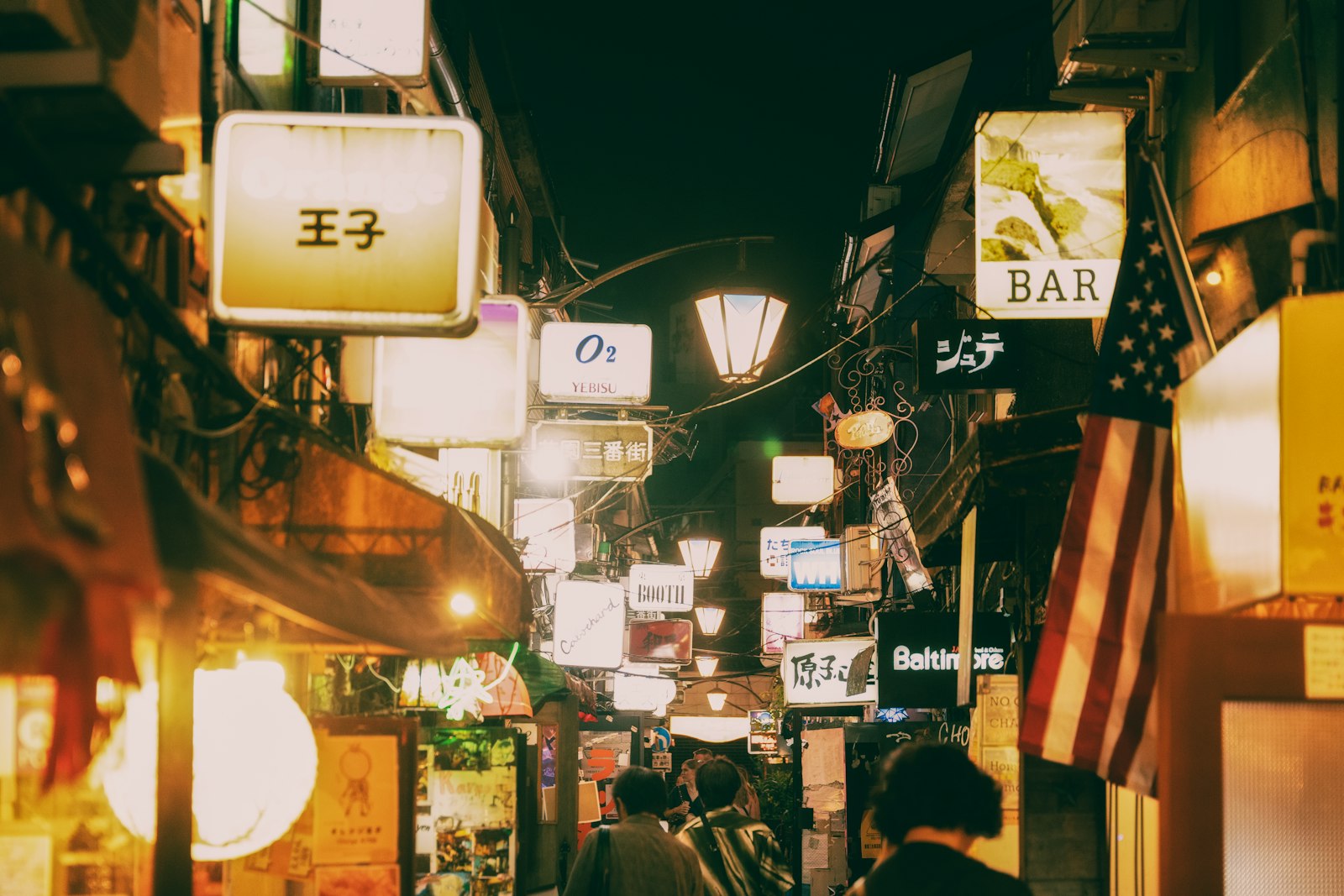 Narrow Golden Gai alley in Shinjuku lined with tiny bars and hanging lanterns