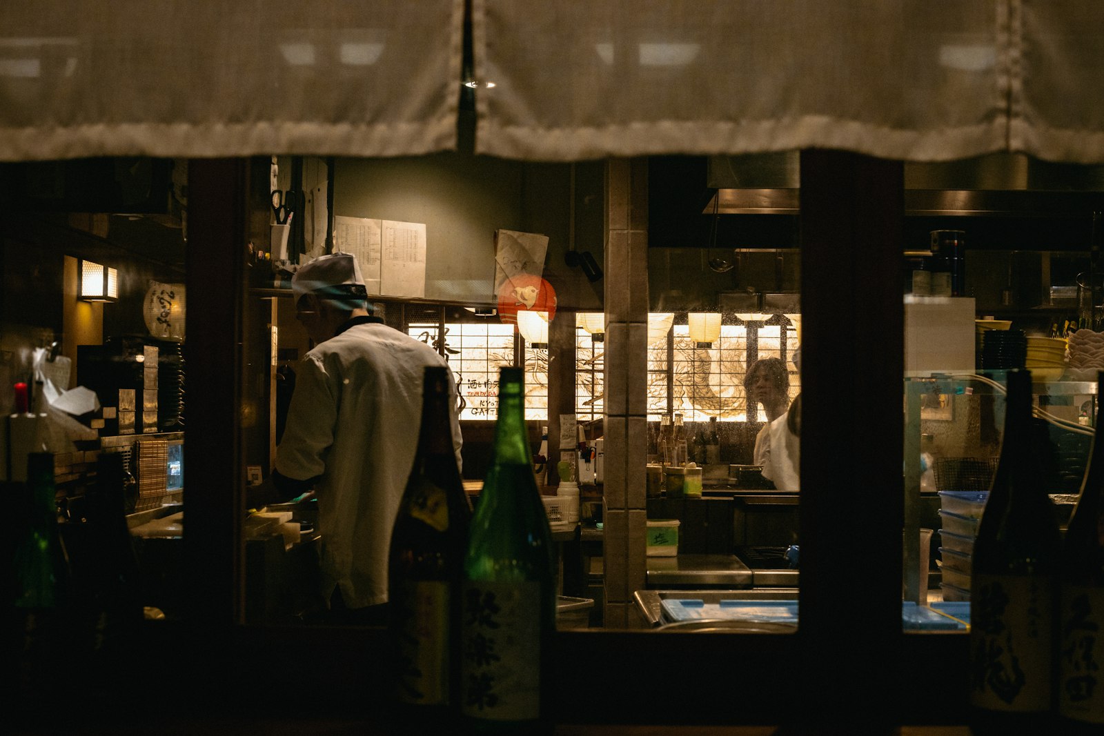 Dimly lit Tokyo lounge interior with a low table and glassware, similar to a kyabakura floor