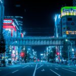 Neon signs and anime billboards lining the main street of Akihabara, Tokyo, at dusk