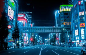Neon signs and anime billboards lining the main street of Akihabara, Tokyo, at dusk