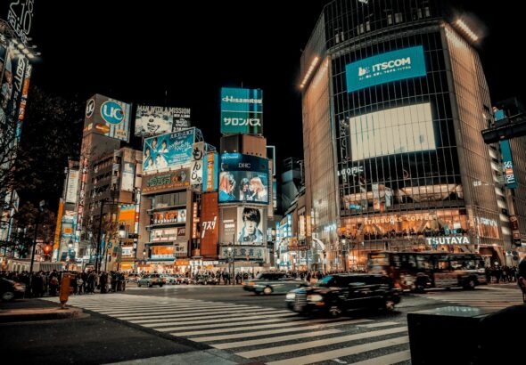City lights spread to the horizon below a high-rise terrace, the classic Tokyo skyline seen after dark