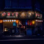 Customers drinking at the counter of a Tokyo tachinomi standing bar at night
