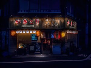 Customers drinking at the counter of a Tokyo tachinomi standing bar at night