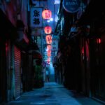 A narrow Tokyo alley lined with red lanterns and glowing standing bar doorways after dark