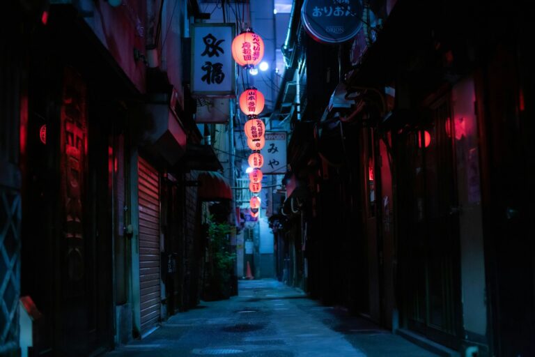 A narrow Tokyo alley lined with red lanterns and glowing standing bar doorways after dark