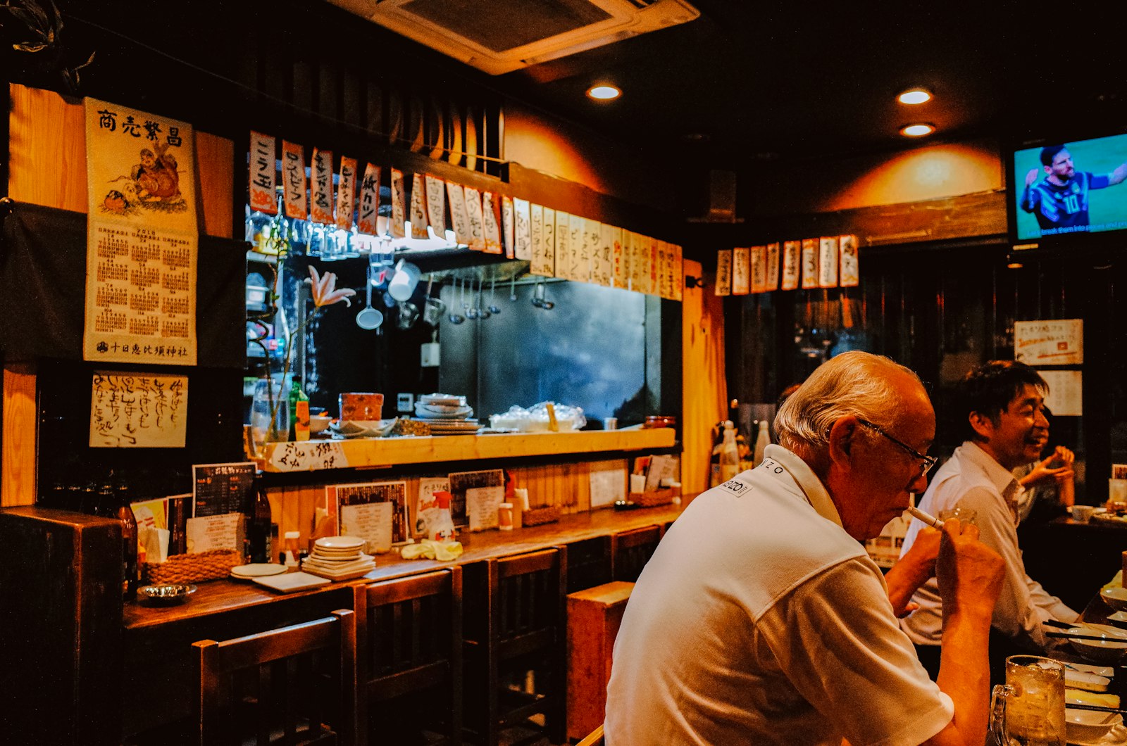 Wooden counter and paper lanterns inside a traditional Tokyo izakaya