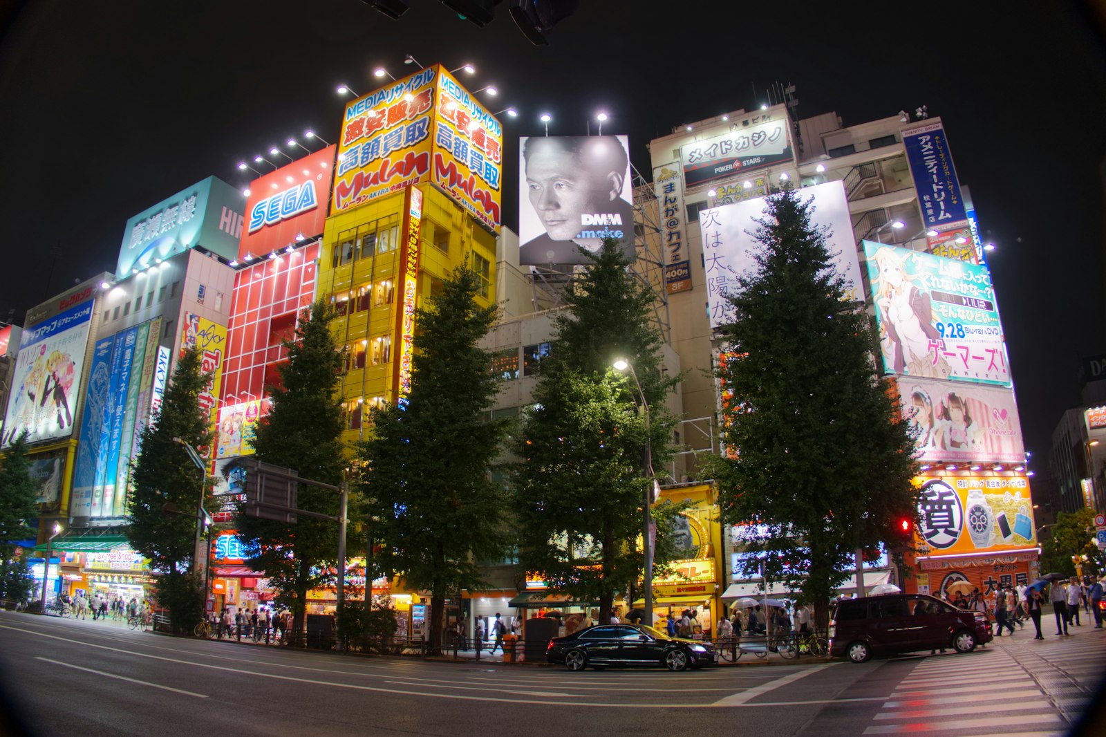 Akihabara's neon-lit main street at night, the heart of Tokyo's anime bar scene