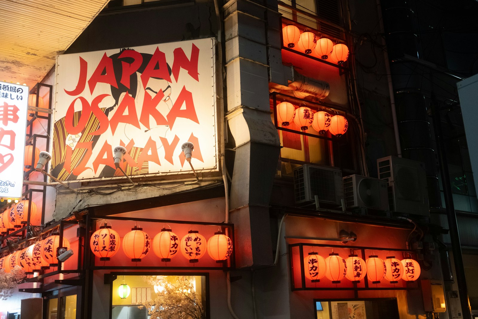 Red lanterns outside a Tokyo izakaya at night, typical of the city's older drinking districts