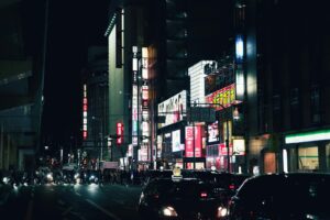 Crowds on a neon-lit Shinjuku street in the early evening, the best time to go out in Tokyo for izakaya