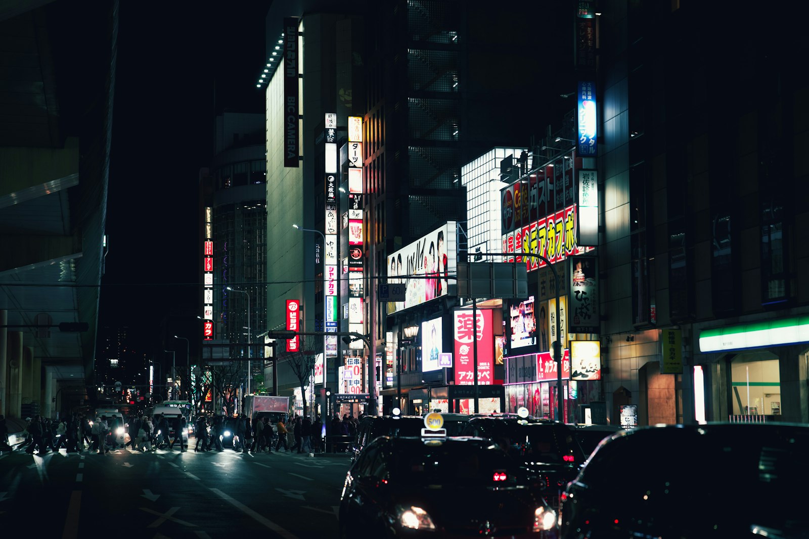 Crowds on a neon-lit Shinjuku street in the early evening, the best time to go out in Tokyo for izakaya