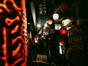 Narrow lantern-lit yokocho alley in Tokyo at night lined with tiny izakaya bars