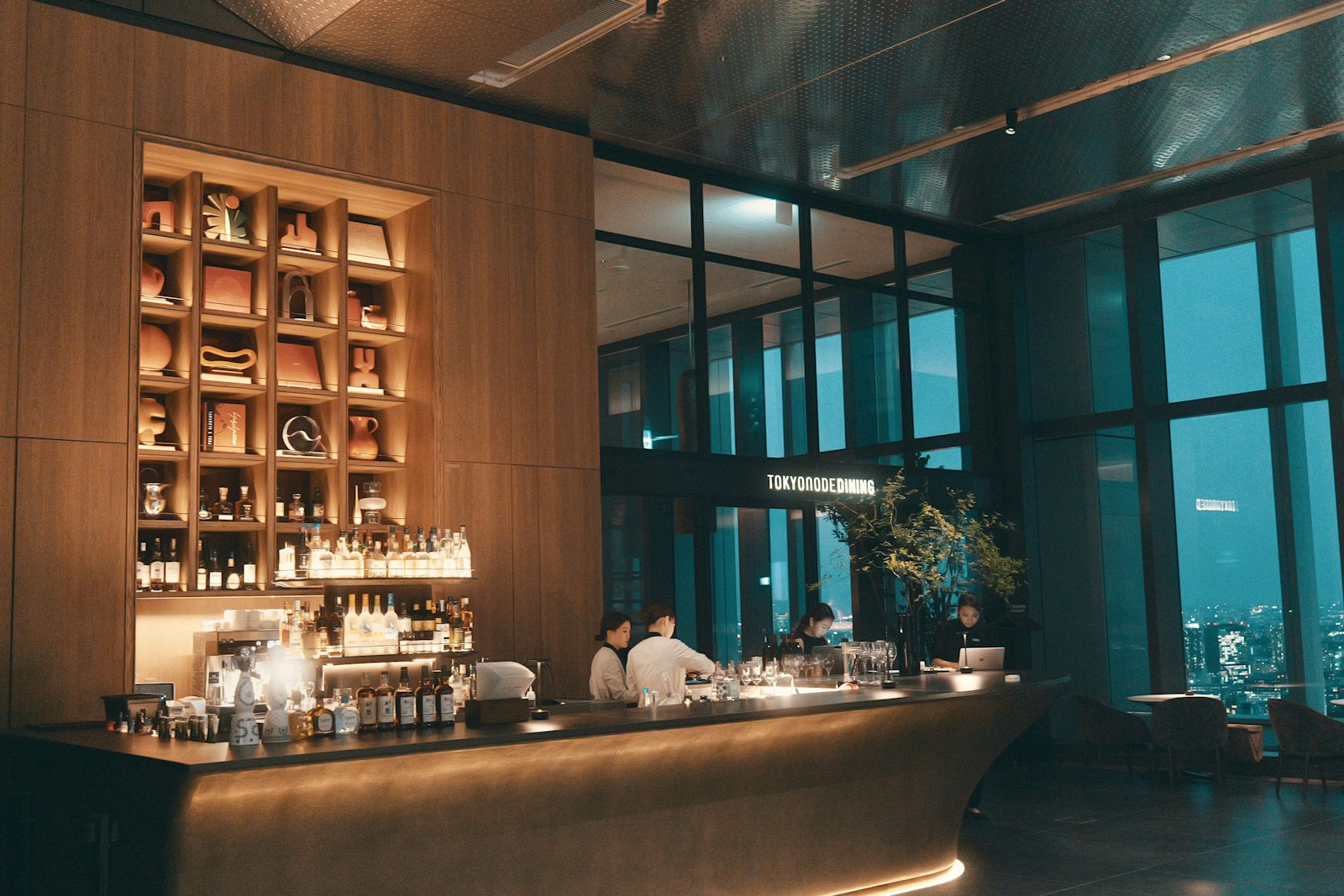 Interior of a Tokyo hostess bar with warm lighting and a drinks counter