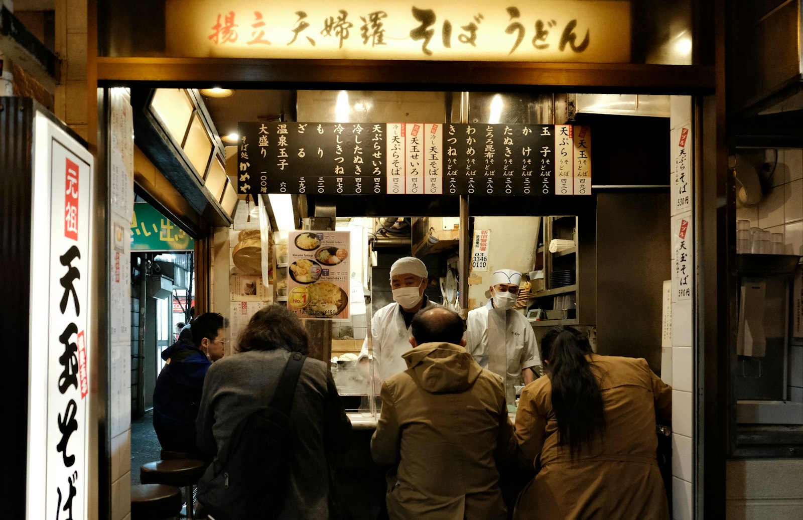 People drinking at a lively Tokyo bar at night during a craft beer bar crawl