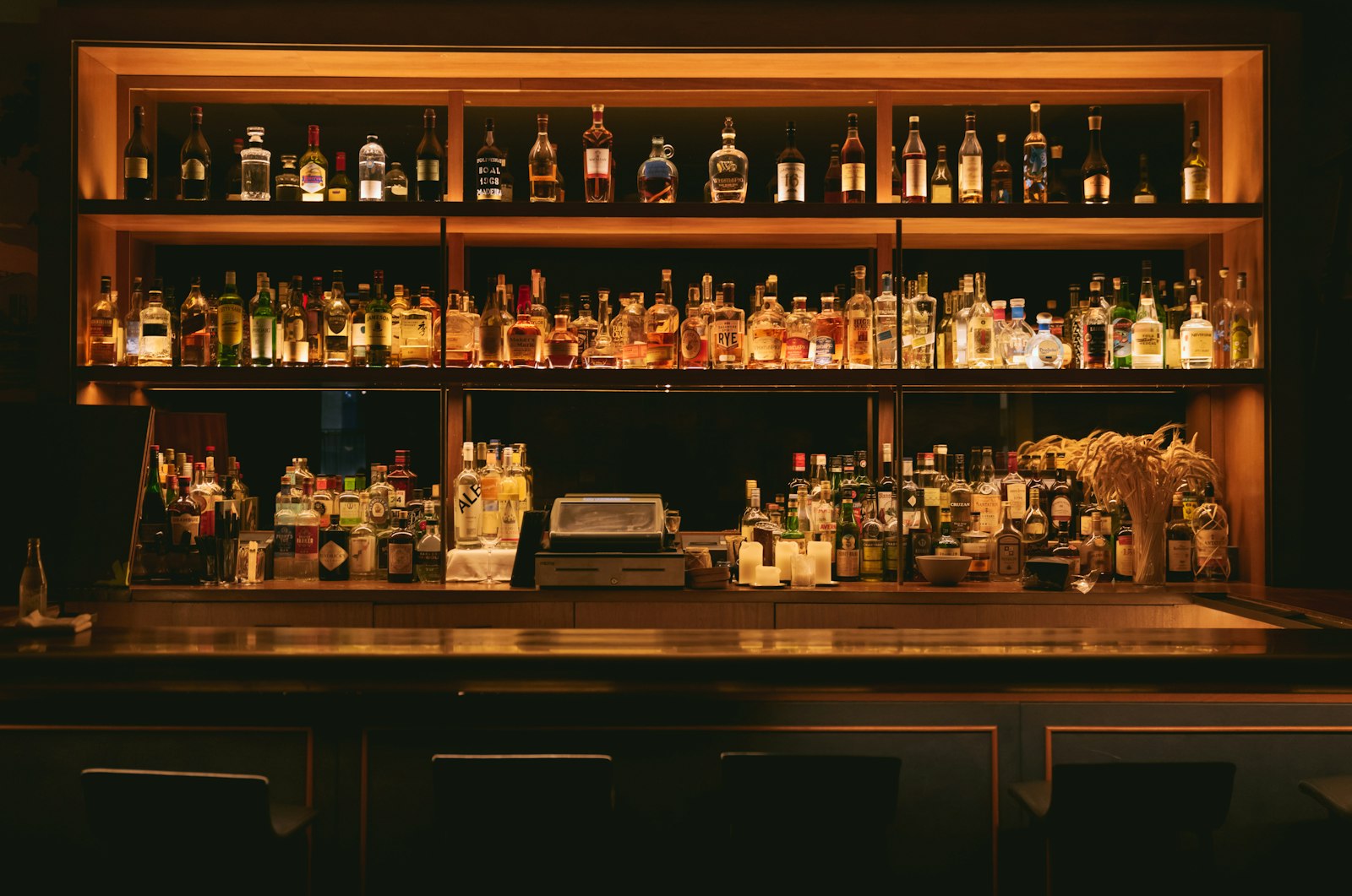 Whisky bottles and a karaoke setup at a Japanese snack bar counter, where bottle keep is standard