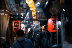 Lantern-lit alley of Omoide Yokocho in Shinjuku at night, lined with tiny yakitori counters
