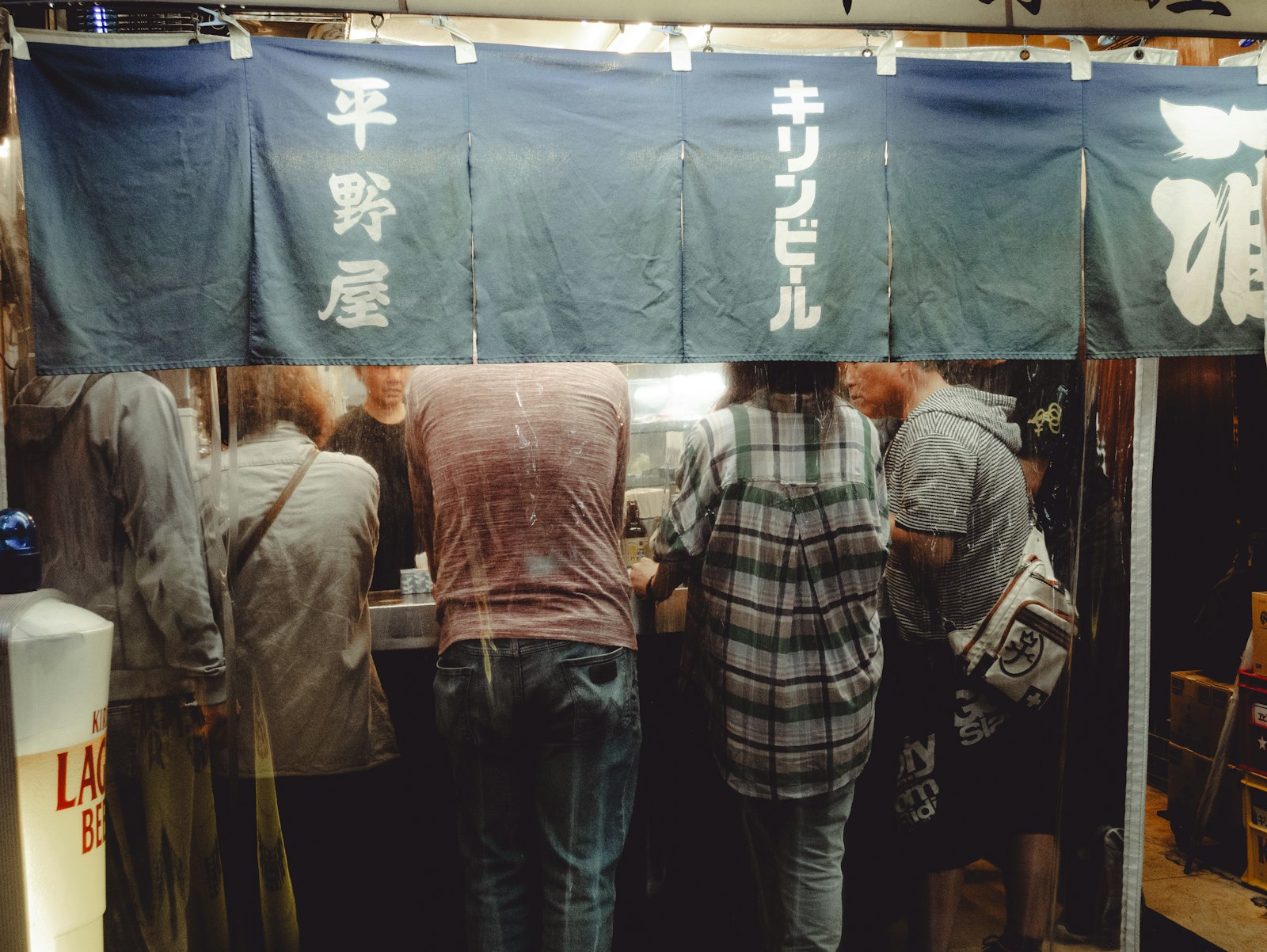Izakaya counter with beer and yakitori skewers, one of the cheapest ways to budget a Tokyo night out