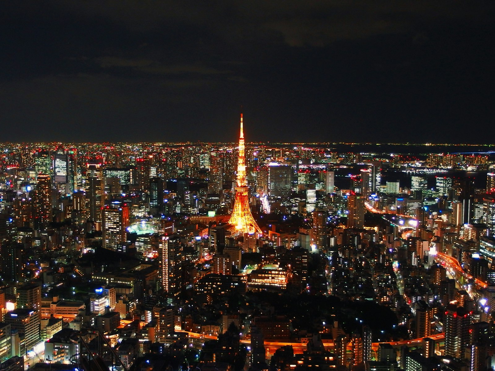 A single seat at a softly lit bar counter in Tokyo at night