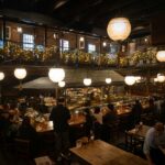 Warm interior of a Tokyo izakaya with red lanterns and counter seating