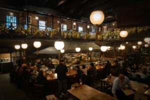 Warm interior of a Tokyo izakaya with red lanterns and counter seating