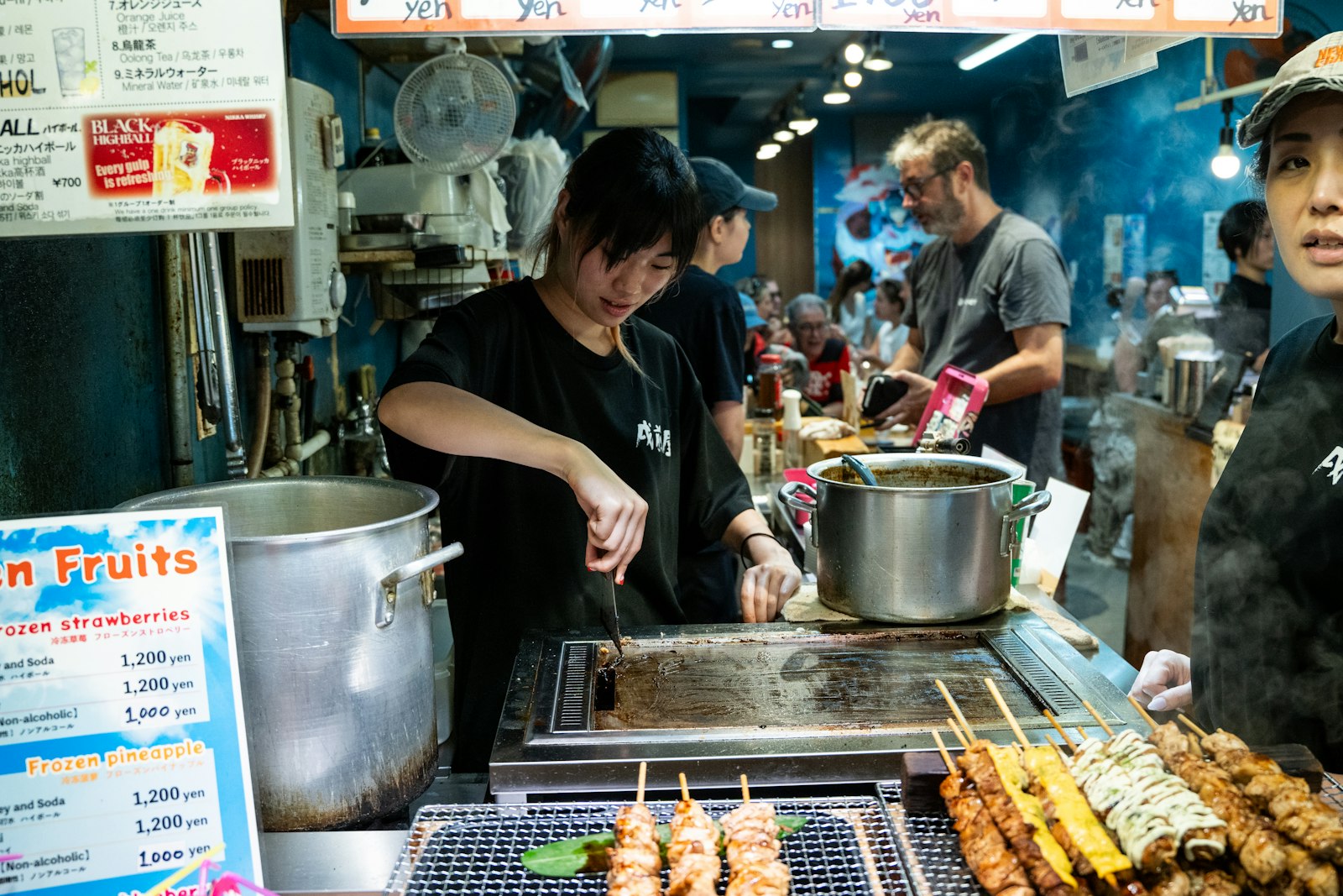 Yakitori skewers grilling over charcoal at a Japanese izakaya