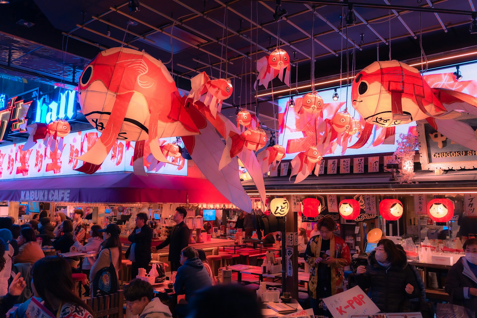 Friends drinking highballs and beer at a busy Tokyo izakaya at night