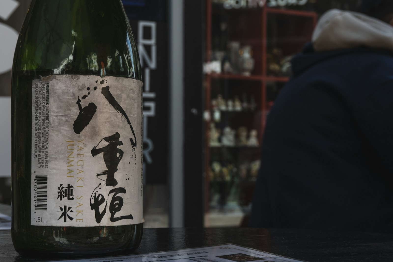 Close-up of a Japanese sake bottle label showing the grade and brewery name