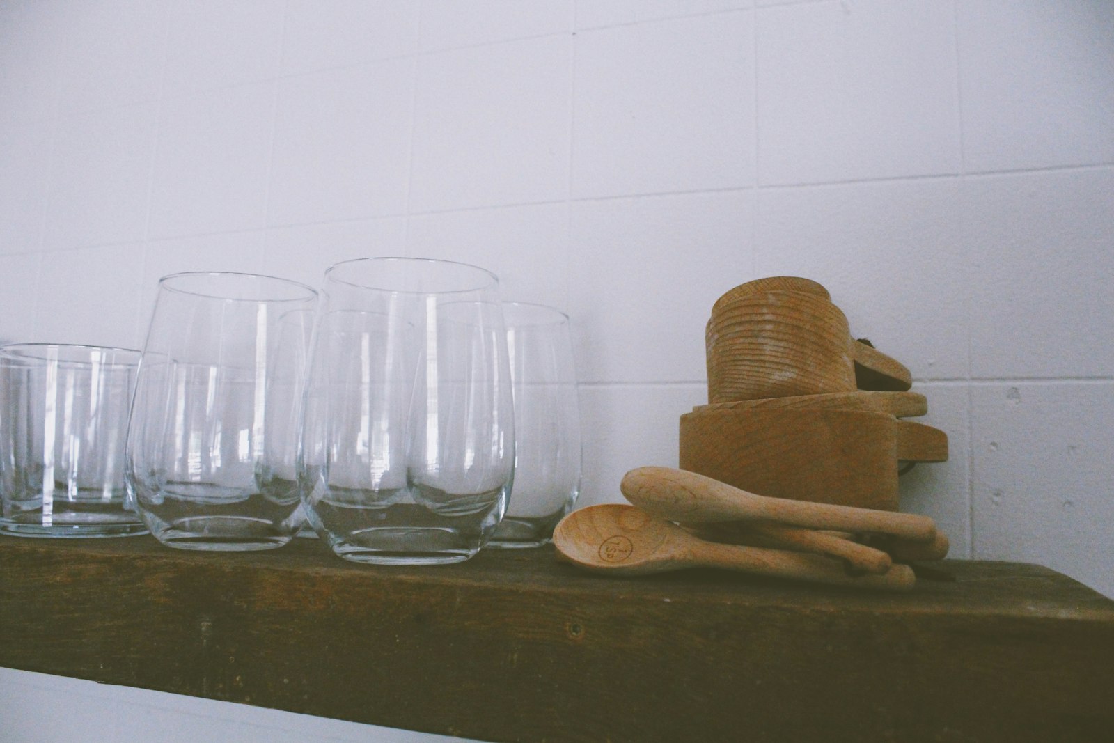 A glass of sake set in a wooden masu cup on a counter, the traditional vessel linked to the word kakuuchi
