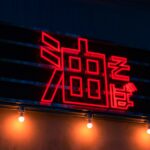 Friends singing in a private karaoke room with colorful lights during a karaoke experience in Tokyo