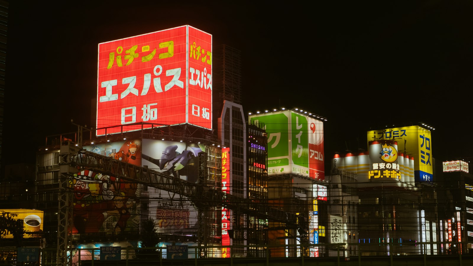 Neon signs on a busy Shinjuku street at night, where many Tokyo karaoke boxes are located