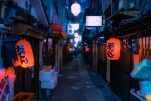 A small ramen shop glowing behind a red lantern on a Tokyo street after midnight