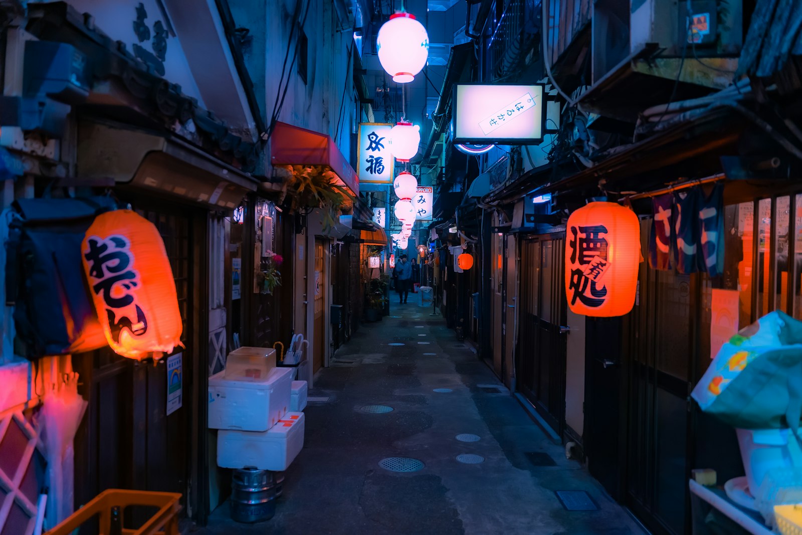 A small ramen shop glowing behind a red lantern on a Tokyo street after midnight
