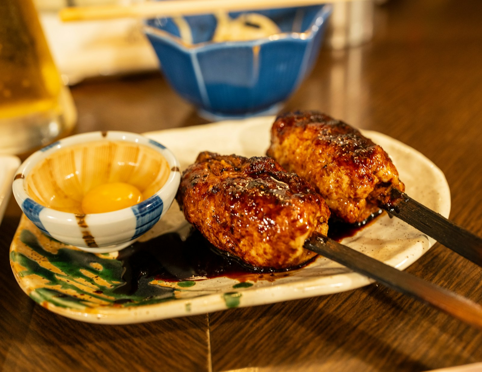 A draft beer and yakitori on an izakaya counter during an after-work drink in Tokyo