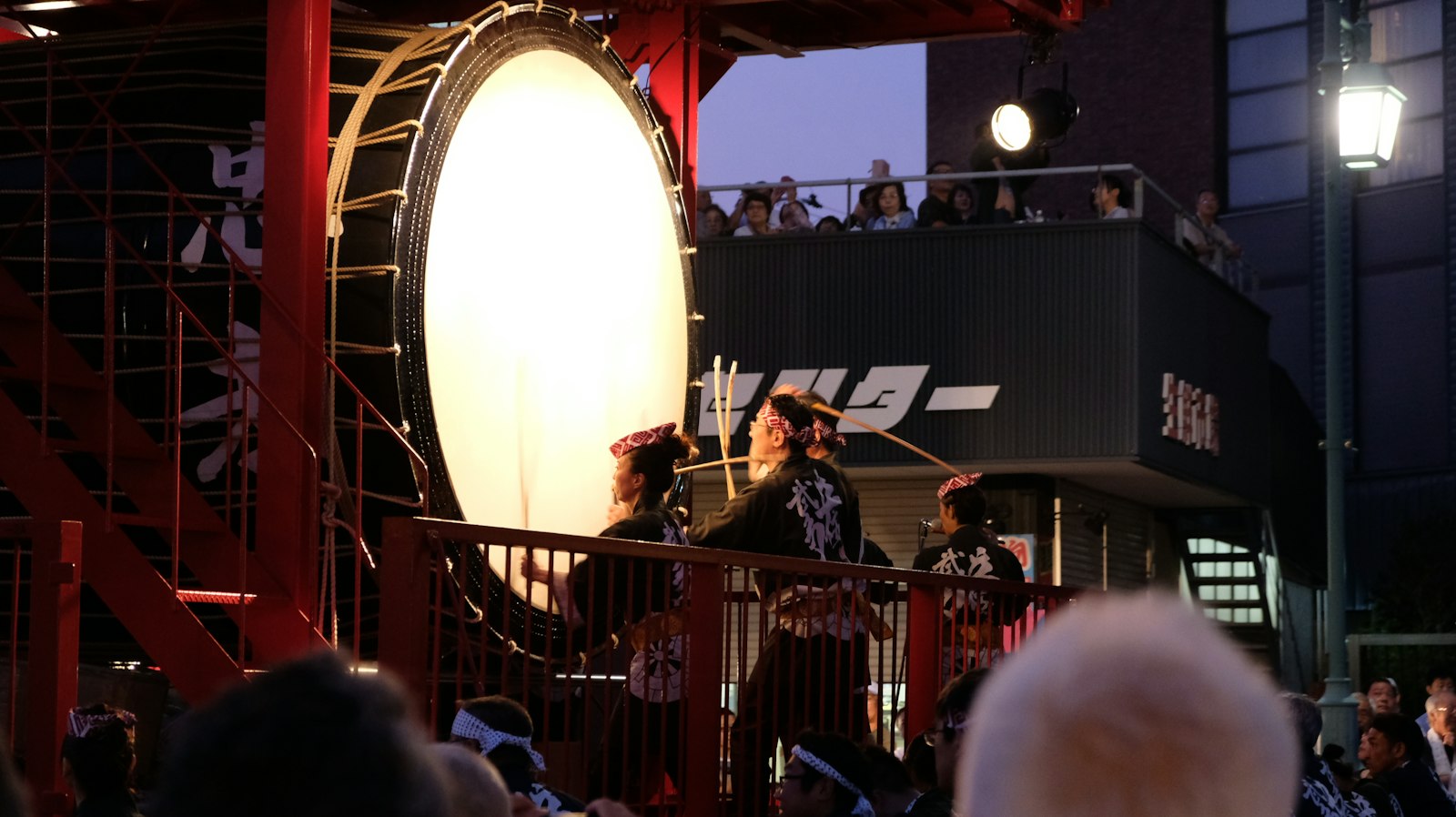 Taiko drummers performing under bright stage lights, similar to the samurai show in Kabukicho