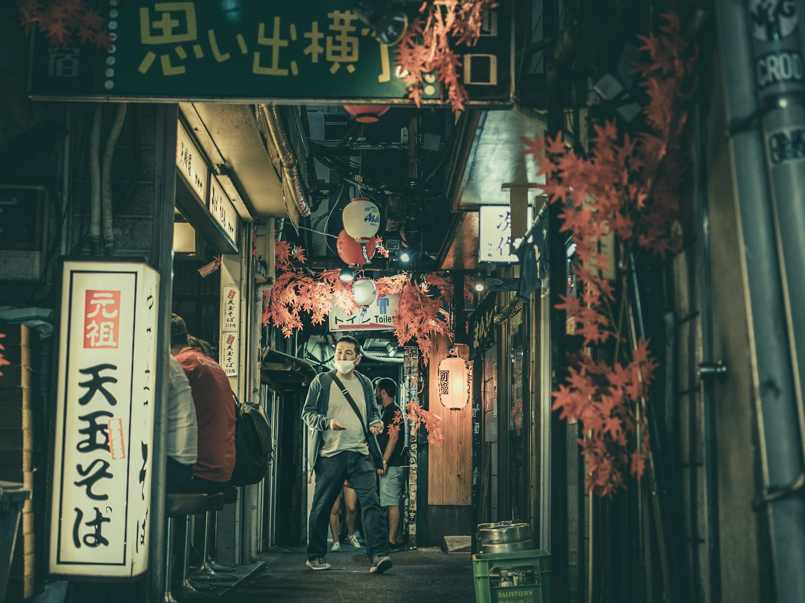 A narrow lantern-lit alley of tiny bars in Tokyo, typical of Golden Gai and Nonbei Yokocho