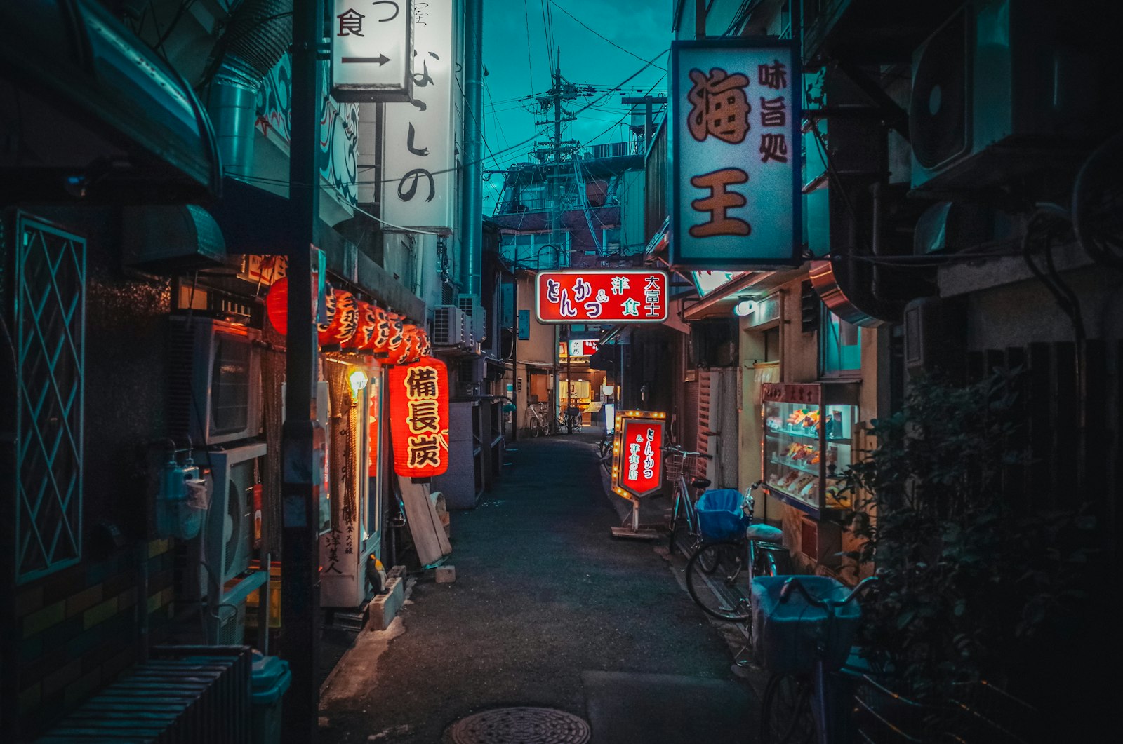 A typical snack bar entrance in Japan, marked only by a small backlit sign on a narrow building stairway