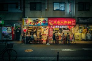 A small snack bar counter in Tokyo lined with bottles, the kind of intimate space where the mama-san serves regulars