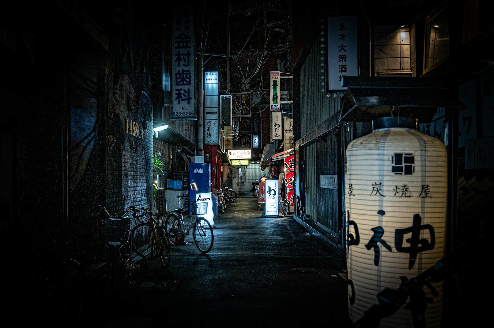 Stacked signs on a Tokyo building advertising small second-floor bars, typical of where snack bars hide